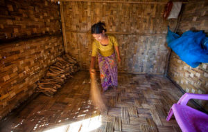 Sobeerakatton Kassim, 15, nettoie la maison en bambou de sa famille (Source: www.bastamag.net)
